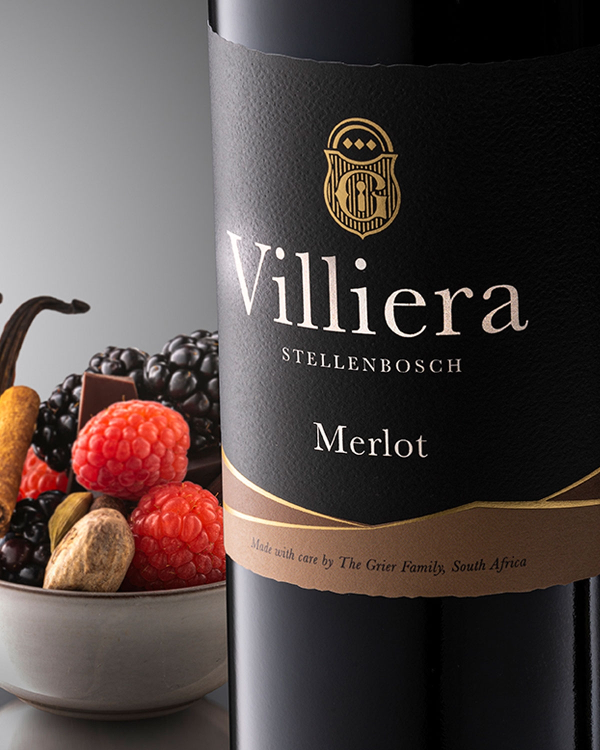 Eine Flasche Villiera Merlot Wein mit einem schwarz-goldenen Etikett, auf dem der Markenname, die Rebsorte und die Herkunft Stellenbosch, Südafrika, angegeben sind. Die Flasche hat ein dunkles Glas und eine schwarze Kappe.