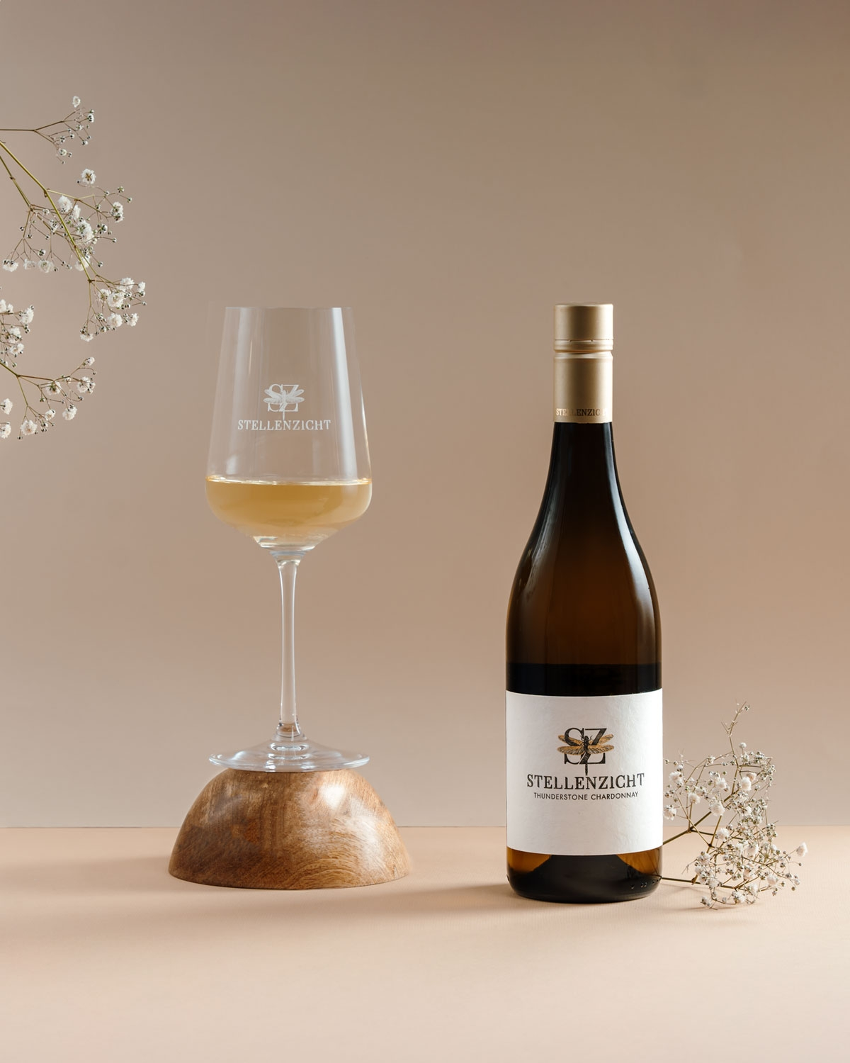 Eine Flasche Stellenzicht Thunderstone Chardonnay mit goldenem Schraubverschluss, weißem Etikett mit Libellenmotiv und schwarzem Text, der den Namen und die Sorte des Weins angibt.